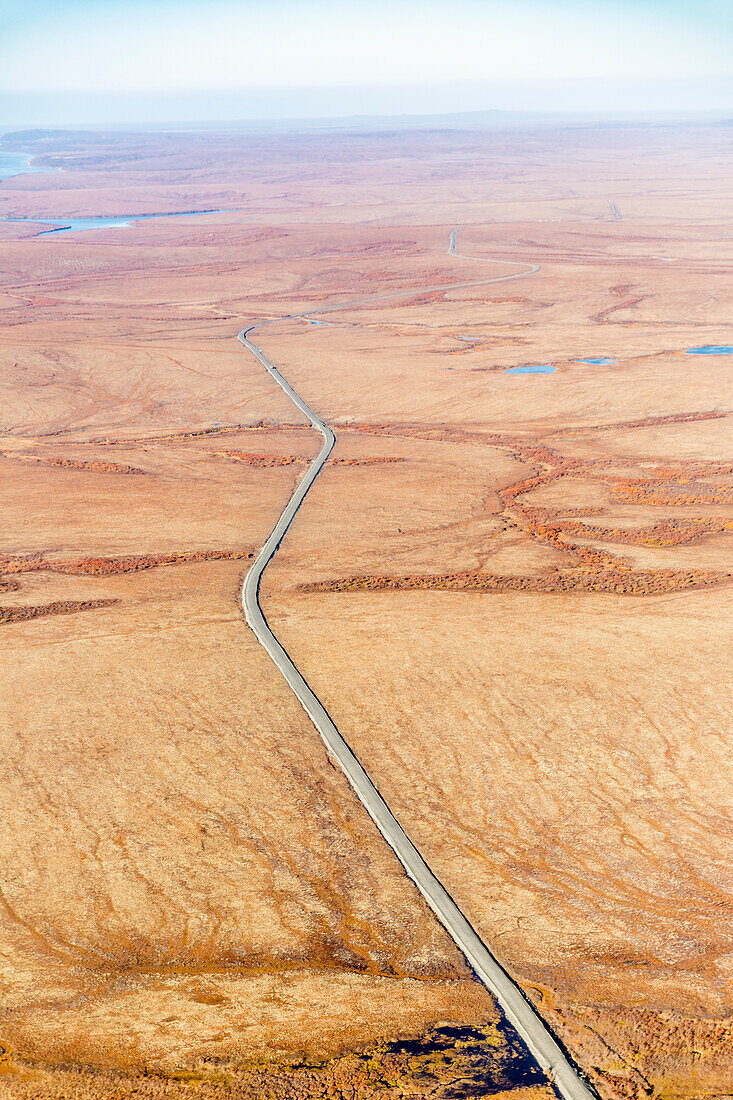Aerial view of autumn coloured tundra surrounding the gravel road which connects St. Mary's to Mountain Village, Yukon Delta, Arctic Alaska, Saint Mary's, Alaska, United States of America