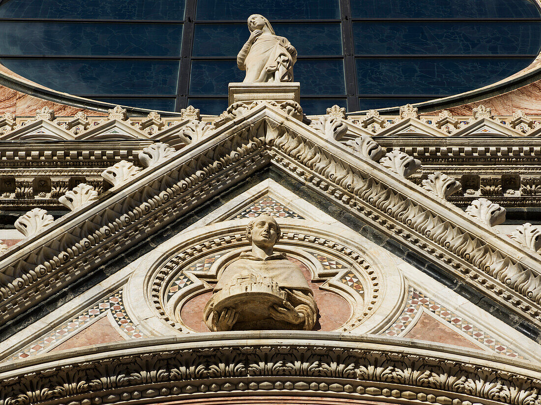 Low angle view of the ornate facade of Siena Cathedral, Siena, Italy