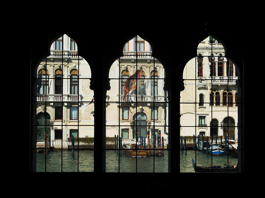 View of a canal through three decorative windows in a row, Venice, Italy