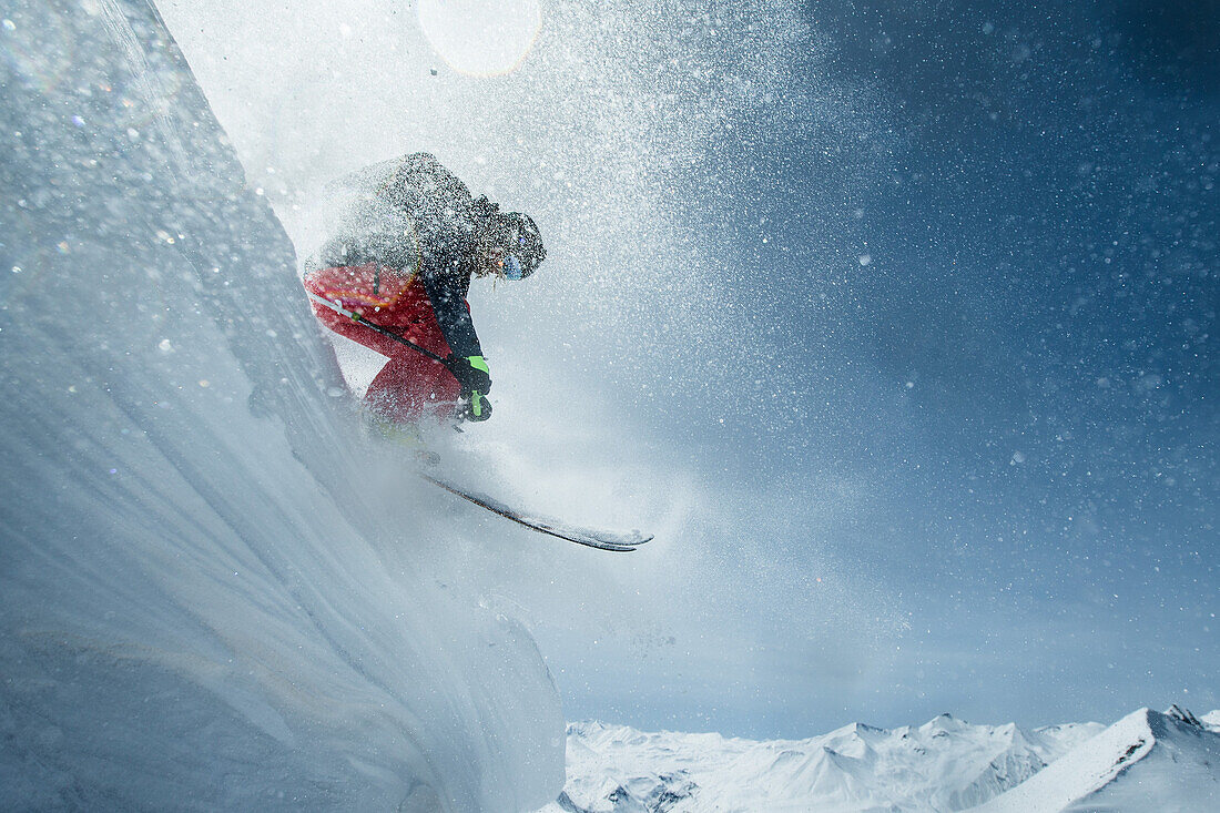 Young female skier jumping down a snowdrift in the mountains, Gudauri, Mtskheta-Mtianeti, Georgia