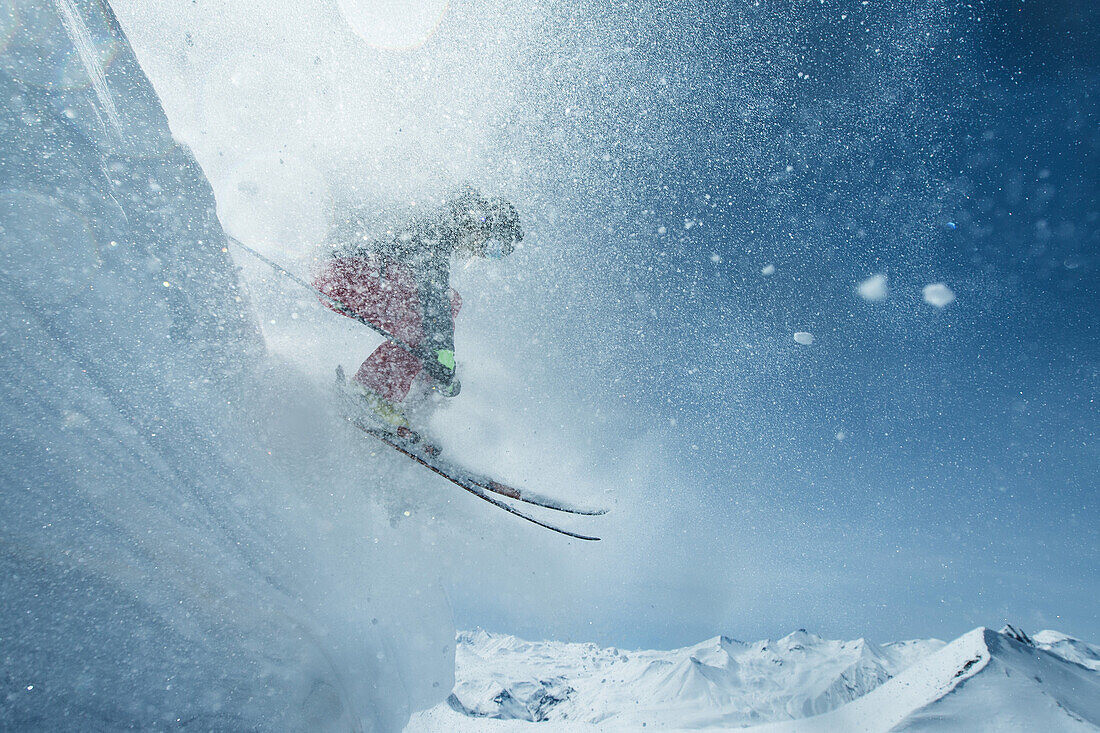 Young female skier jumping down a snowdrift in the mountains, Gudauri, Mtskheta-Mtianeti, Georgia