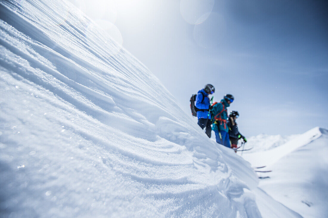 Three young skiers standing on a snowdrift in the mountains, Gudauri, Mtskheta-Mtianeti, Georgia