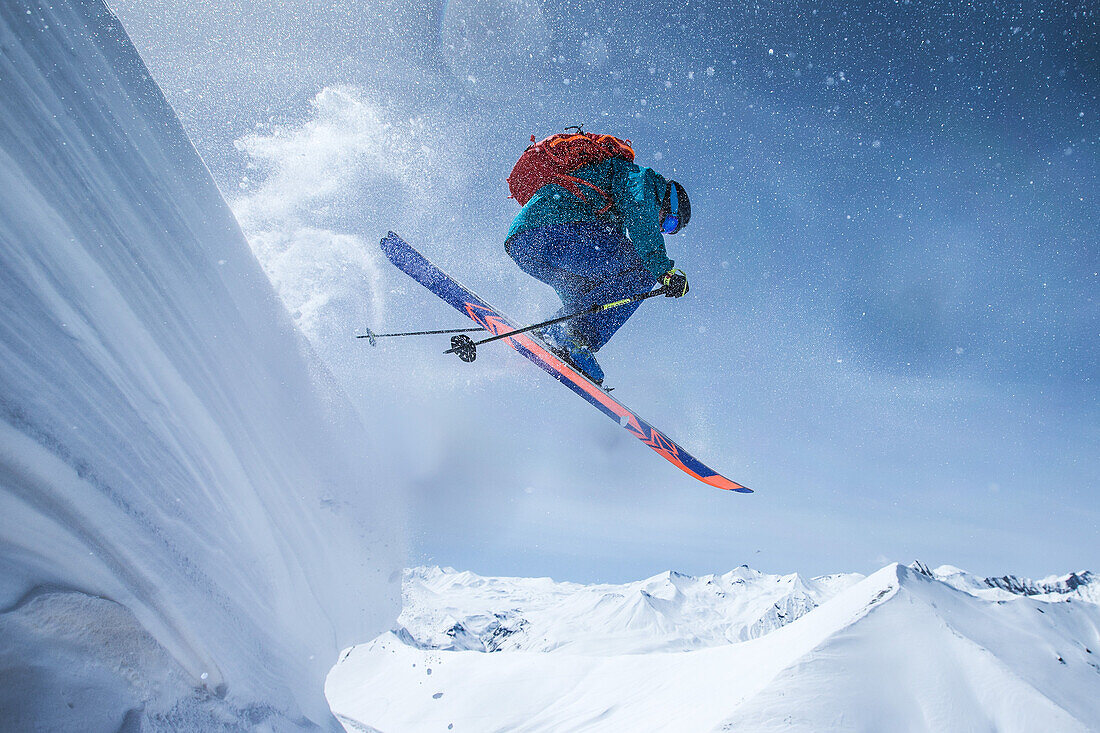 Junger Skifahrer springt eine Schneewehe in den Bergen herunter, Gudauri, Mzcheta-Mtianeti, Georgien