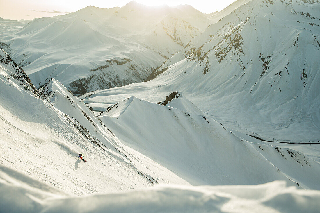 Young female skier riding apart the slopes through the deep powder snow, Gudauri, Mtskheta-Mtianeti, Georgia