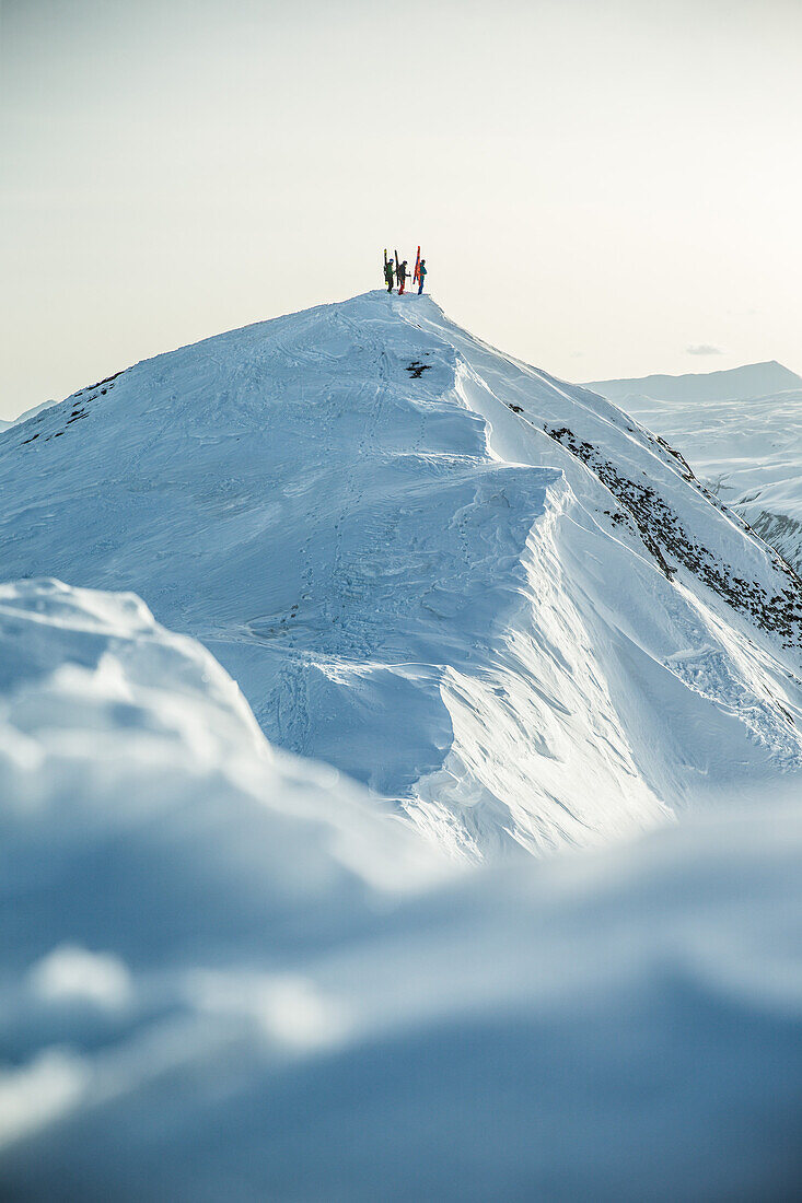 Three young skiers standing on a mountain peak, Gudauri, Mtskheta-Mtianeti, Georgia