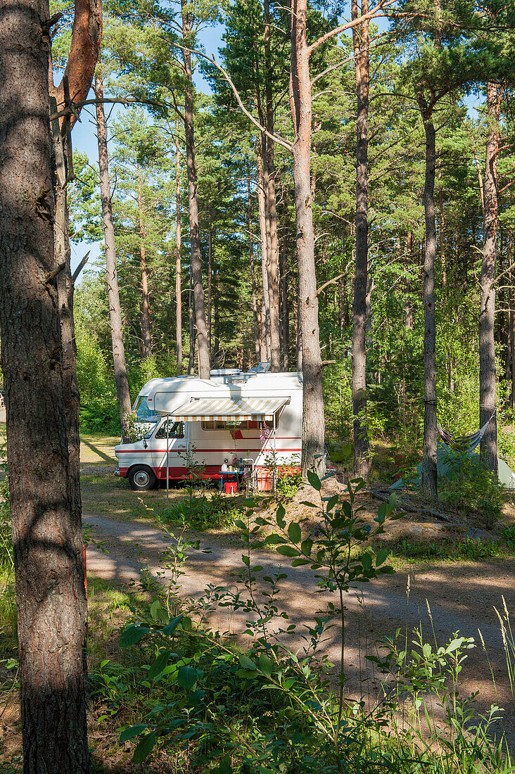 View to a camper in the woods of the campsite of castle Lacko, lake Vanern, Kallandso, Lidkoping, Vastergotland, Sweden
