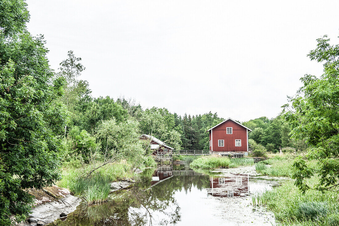 Alte Mühle mit rotem Holzhaus auf dem Land in Västergötland, Schweden