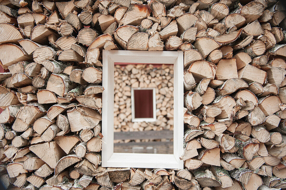 view through a small window within a stack of birch firewood, Vastergotland, Sweden