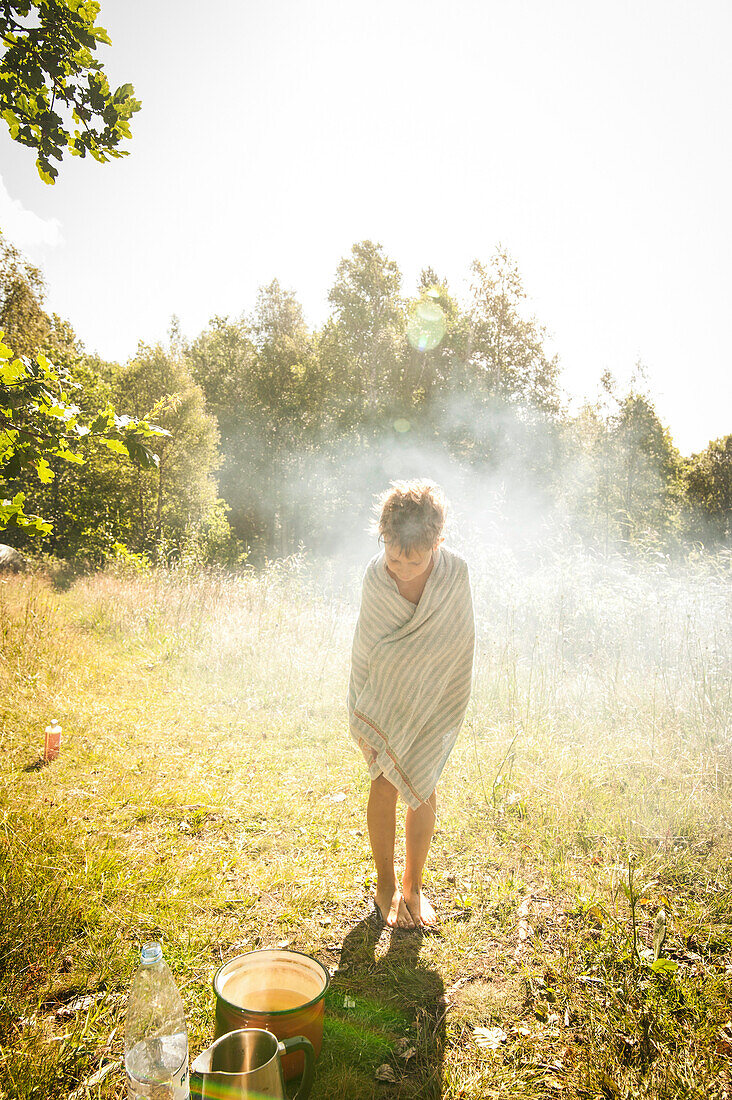 child after a shower in a meadow with morning sun, Halland, Sweden