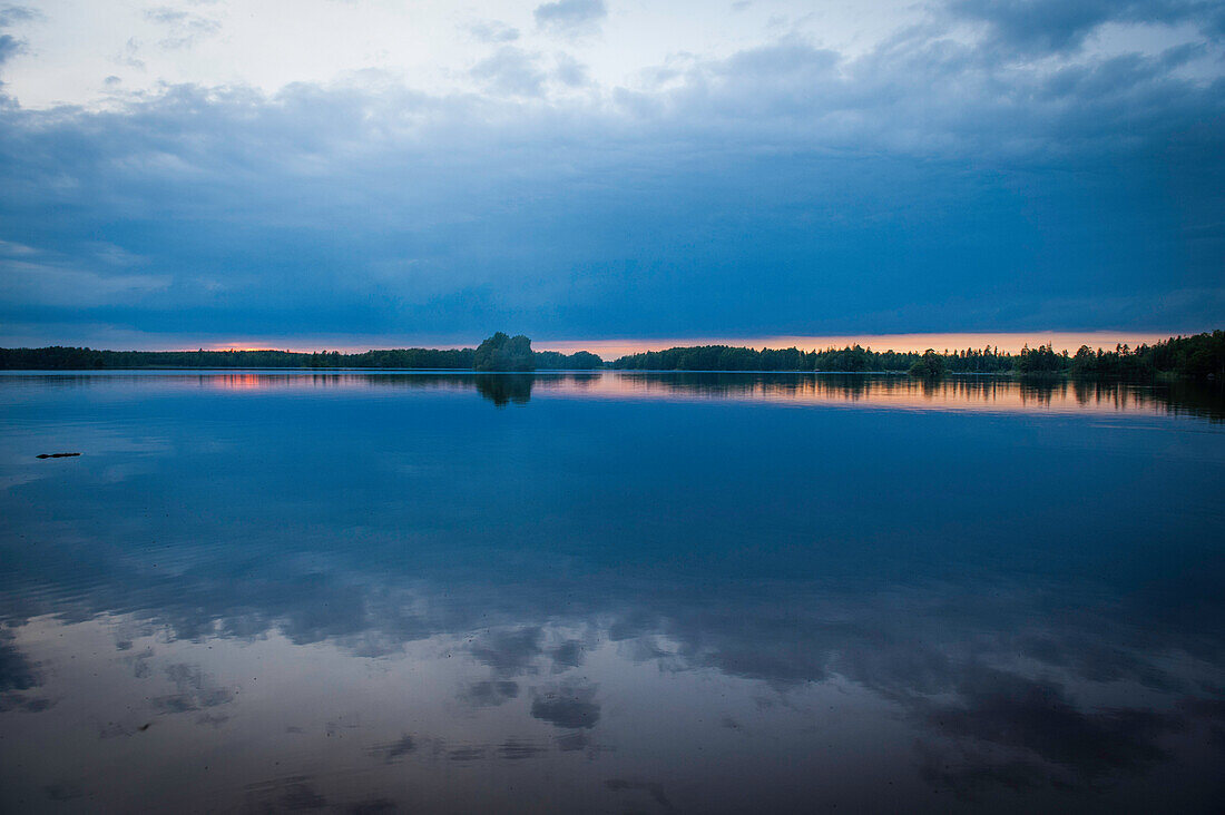 Untergehende Sonne auf einem See in Smaland, Schweden