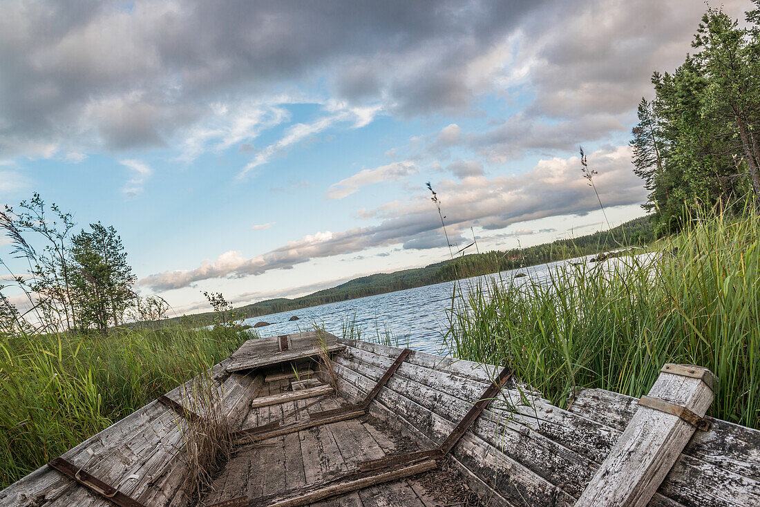 Rotten fishing boat on the shore of a small lake near Munkfors, Varmland, Sweden