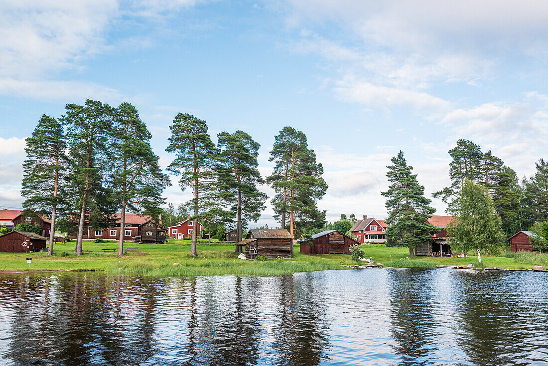 view from water to the village of Bodarna with its red wooden houses, Solleron, Dalarna, Sweden