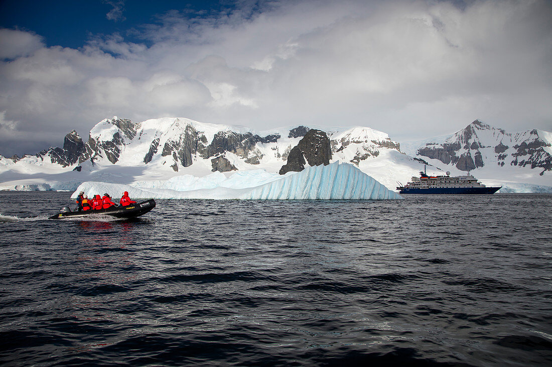Zodiac Schlauchboot Transfer für Passagiere von Expeditions Kreuzfahrtschiff MV Sea Spirit (Poseidon Expeditions) nahe Eisberg, Cuverville Island, Grahamland, Antarktische Halbinsel, Antarktis