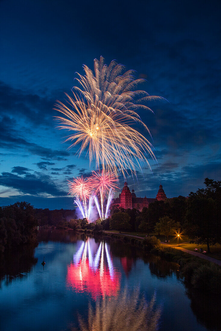 Fireworks iIlluminate the sky above Schloss Johannisburg Palace along Main river at dusk Aschaffenburg, Spessart-Mainland, Franconia, Bavaria, Germany