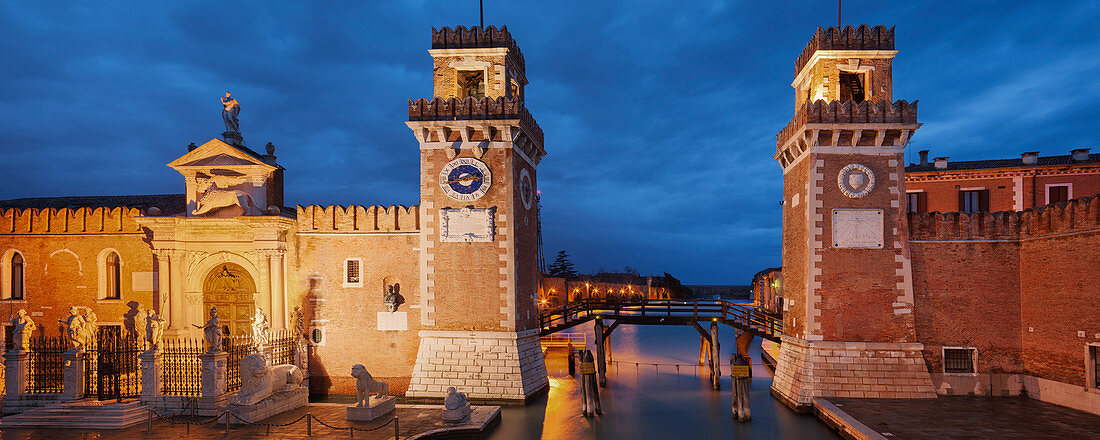 Panorama des Arsenale di Venezia, der ehemaligen Werft und Flottenbasis im Blau der Nacht, mit beleuchteter Mauer und Portal Ingresso di Terra links und Ingresso all'Acqua rechts, Arsenal, Castello, Venedig, Venezien, Italien