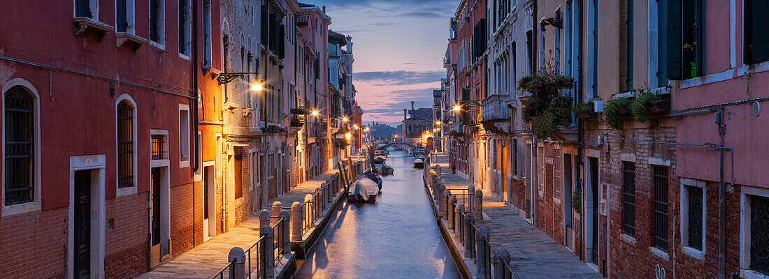 Panorama mit beleuchteten Häusern und Booten am Rio de la Fornace der Morgendämmerung, Dorsoduro, Venedig, Venezien, Italien
