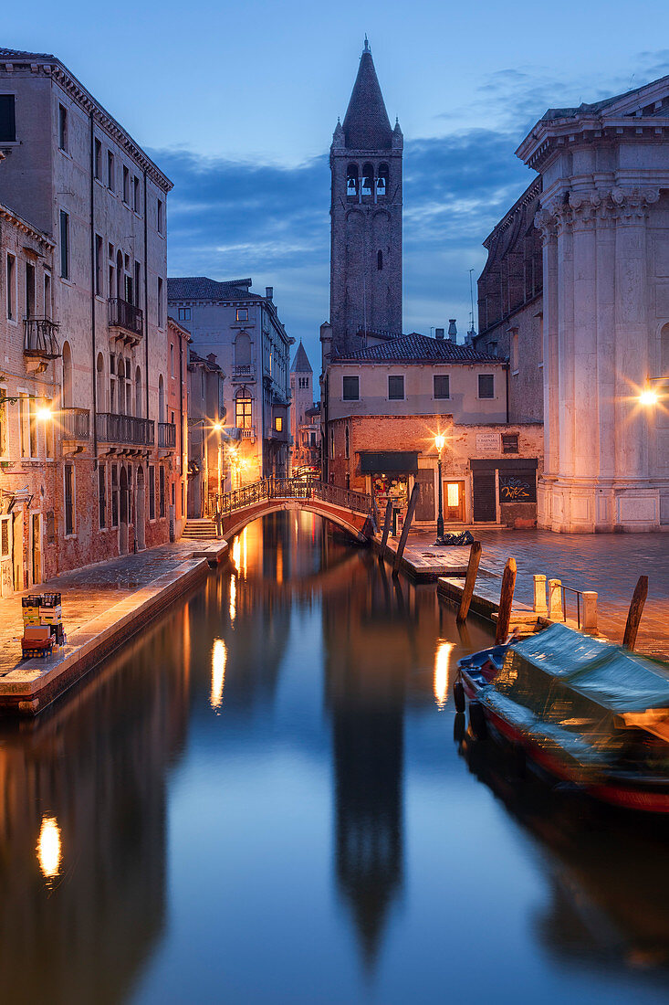 Beleuchtete Häuser am Rio di San Barnaba mit Turm der Kirche Santa Maria dei Carmini und Booten im Blau der Dämmerung, Dorsoduro, Venedig, Venezien, Italien