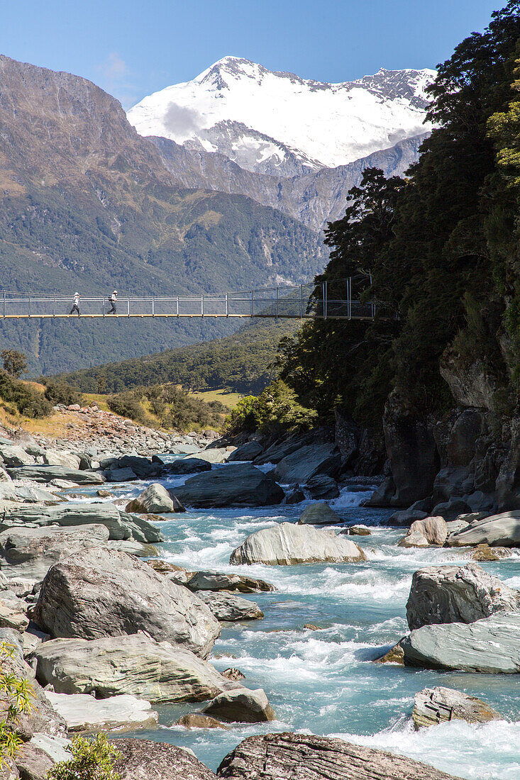 walking swing bridge Matukituki Valley, river, alpine scenery, snowy mountains, Mount Aspiring National Park, Southern Alps, South Island, New Zealand