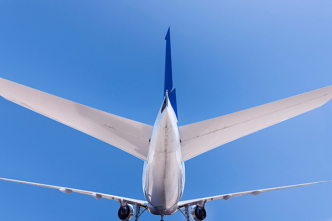 Low angle view of airplane flying in blue sky