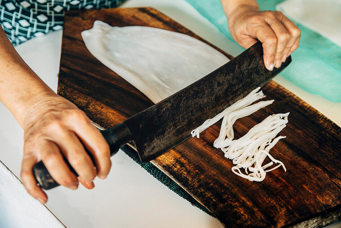 Close up of chef chopping squid on cutting board