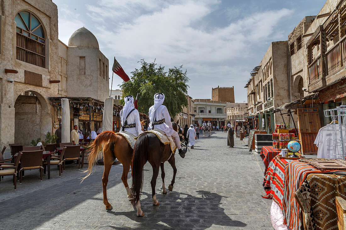Men riding horses on Doha street, Doha, Qatar