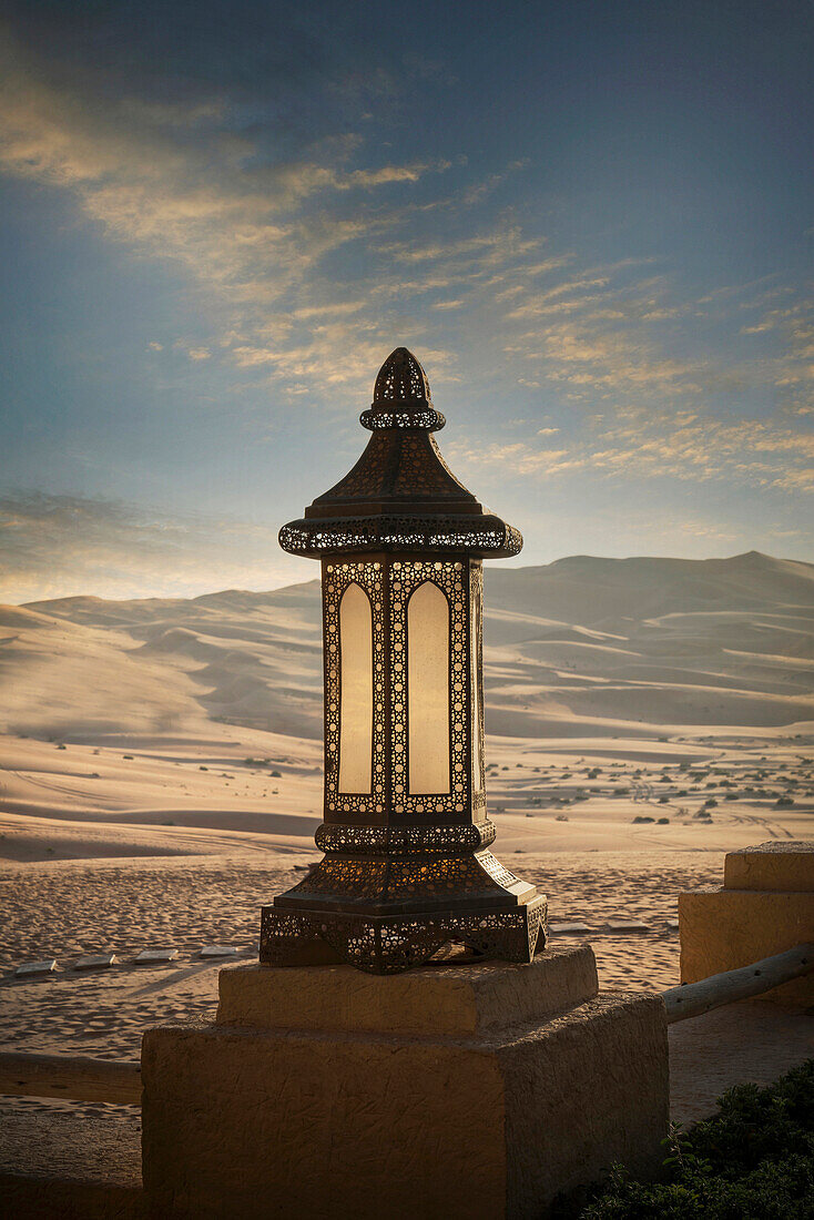 Ornate lantern on wall in desert