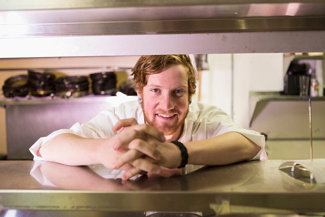 Caucasian chef smiling in restaurant kitchen