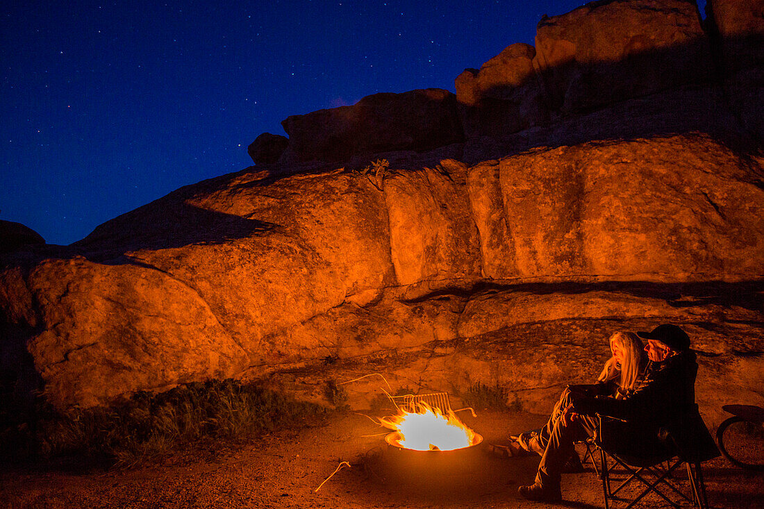 Caucasian couple near campfire at night