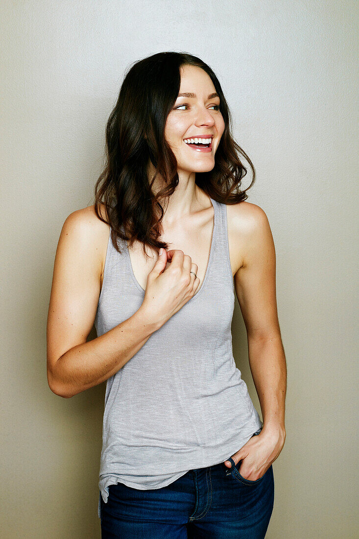 Caucasian woman laughing near wall