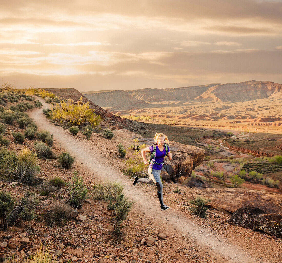Caucasian woman running on remote dirt path