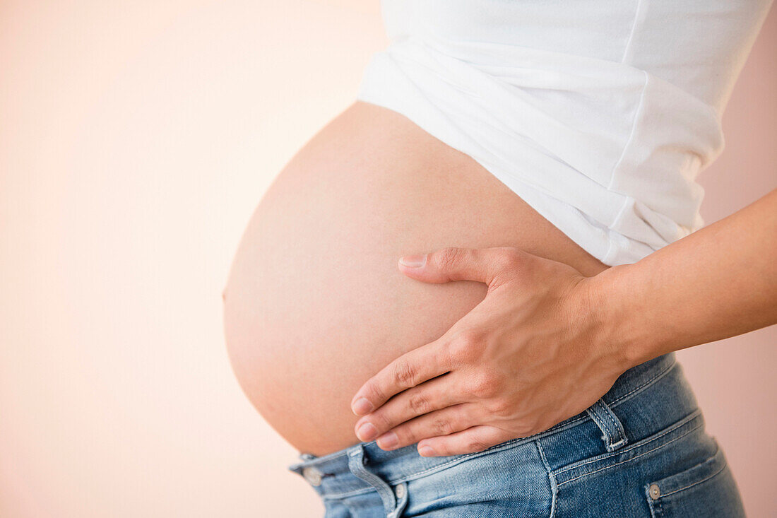 Pregnant Caucasian woman holding her belly