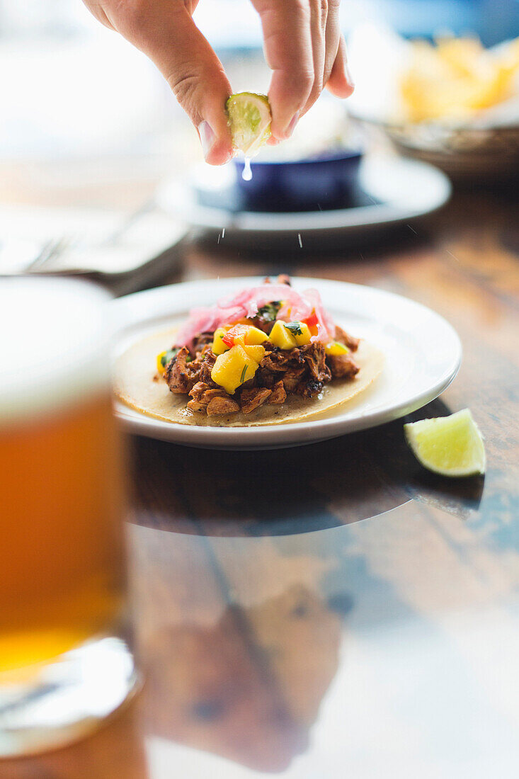 Caucasian man squeezing lime on taco