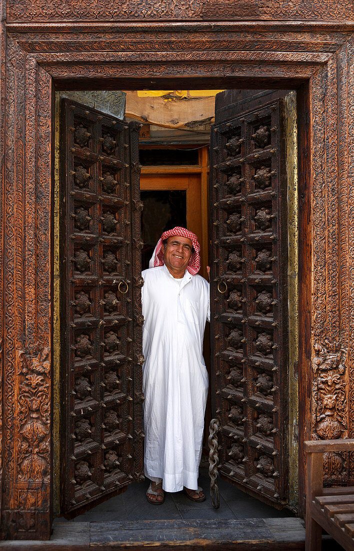 Smiling man opening ornate doors