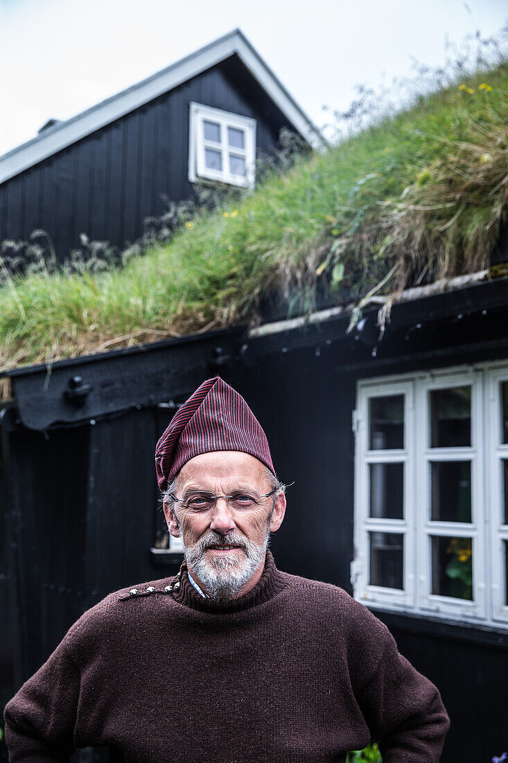 Mann von den Färöer Inseln vor seinem Haus, Färöer Inseln