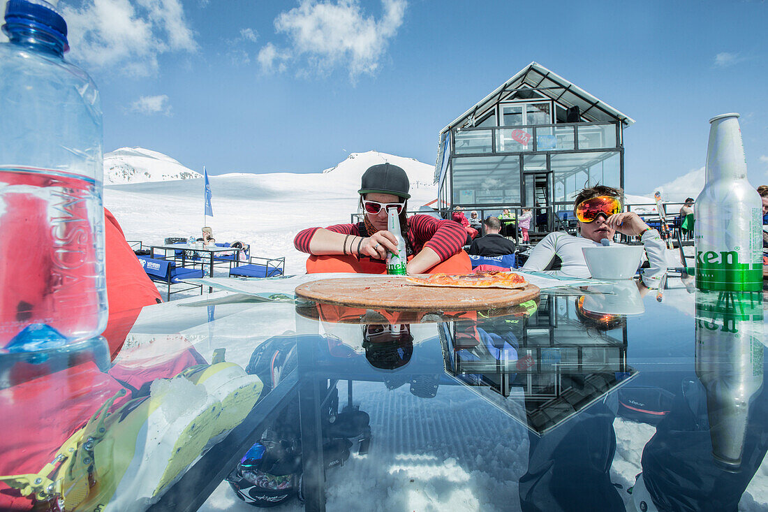 Zwei junge Skifahrer essen etwas in den Bergen, Gudauri, Mzcheta-Mtianeti, Georgien