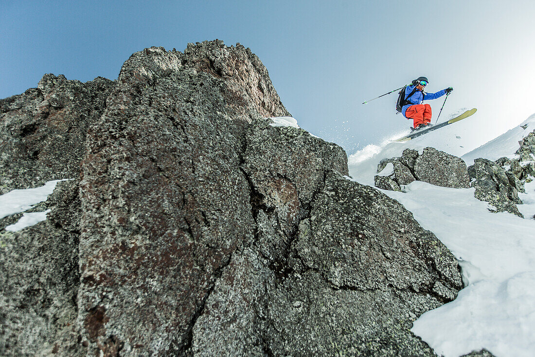 Young female skier jumping down a snowdrift in the mountains, Gudauri, Mtskheta-Mtianeti, Georgia