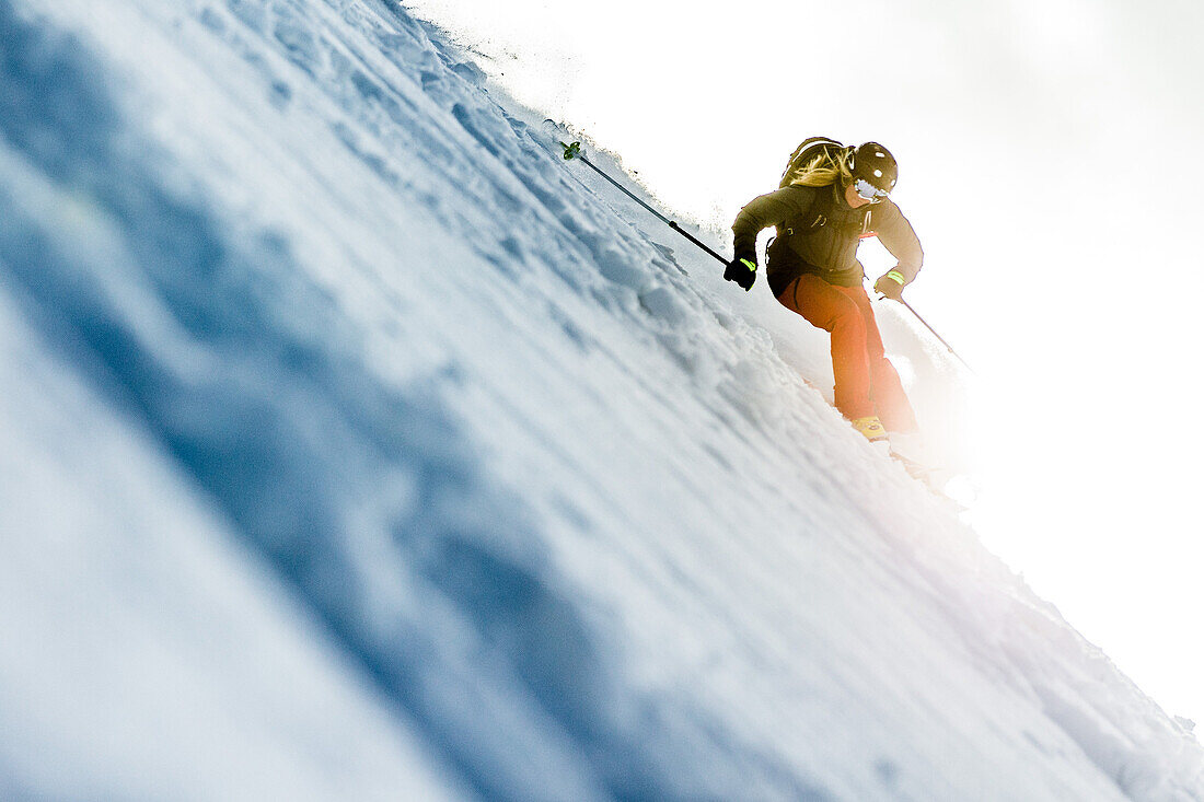 Young female skier riding apart the slopes through the deep powder snow, Gudauri, Mtskheta-Mtianeti, Georgia