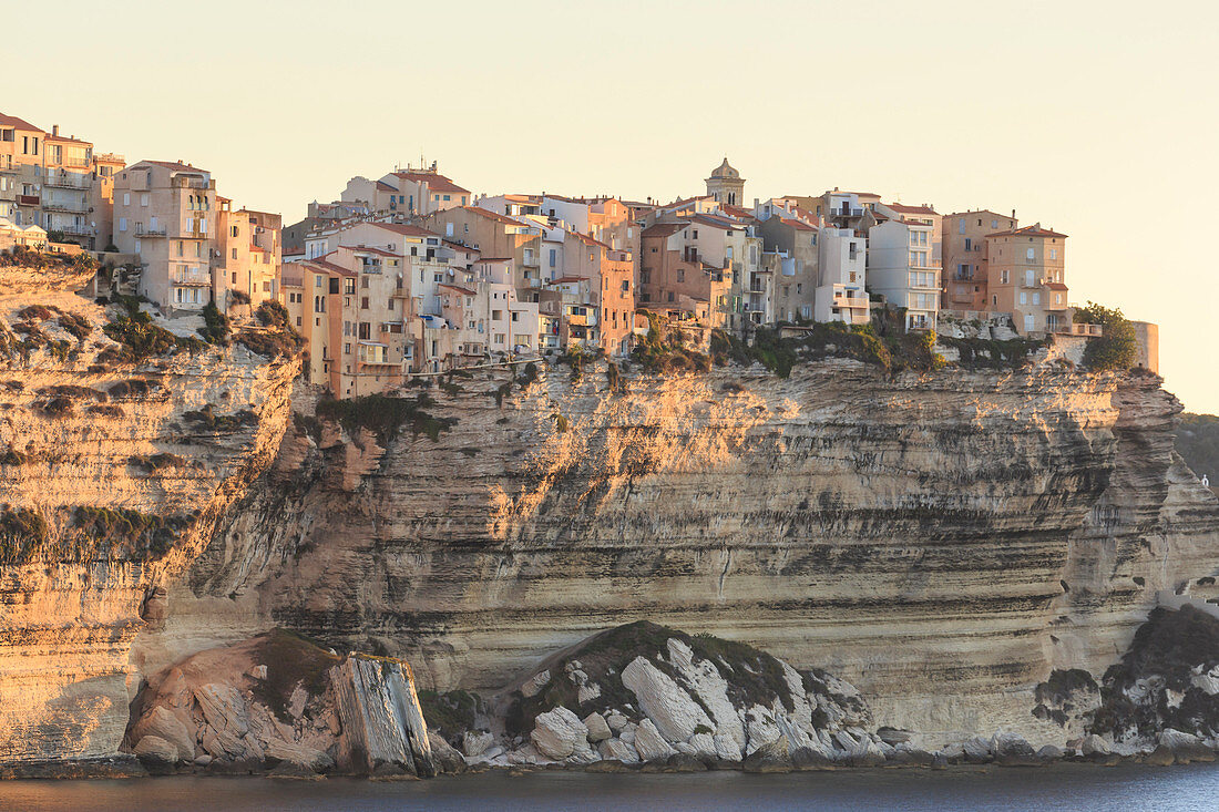 Old citadel townhouses and church at dawn, in early morning light, seen from the sea, Bonifacio, Corsica, France, Mediterranean, Europe
