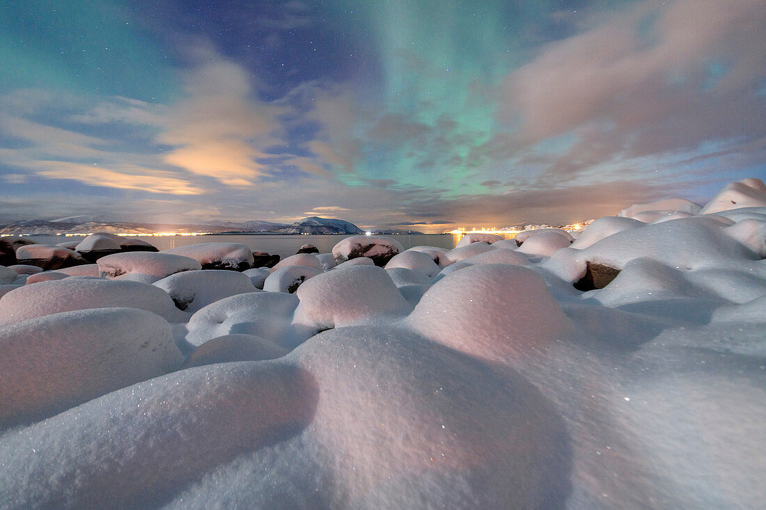 Das rosa Licht und die Aurora Borealis (Nordlichter) beleuchten die verschneite Landschaft auf einer Sternennacht Stronstad, Lofoten, Arktis, Norwegen Skandinavien, Europa