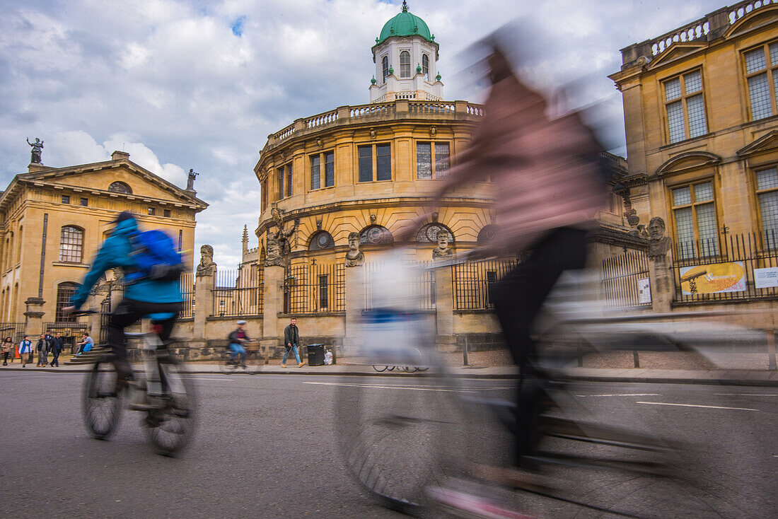 Cyclists passing the Sheldonian Theatre, Oxford, Oxfordshire, England, United Kingdom, Europe