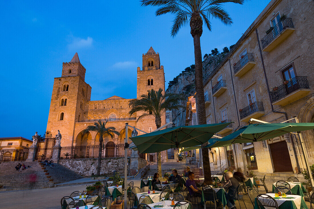 People dining in Piazza Duomo in front of the Norman Cathedral of Cefalu illuminated at night, Cefalu, Sicily, Italy, Europe
