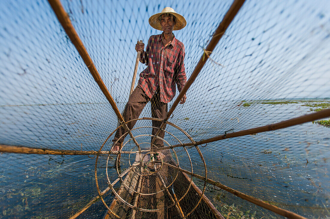 Ein Korbfischer auf Inle See scannt das ruhige und flache Wasser für Zeichen des Lebens, Shan State, Myanmar (Burma), Asien