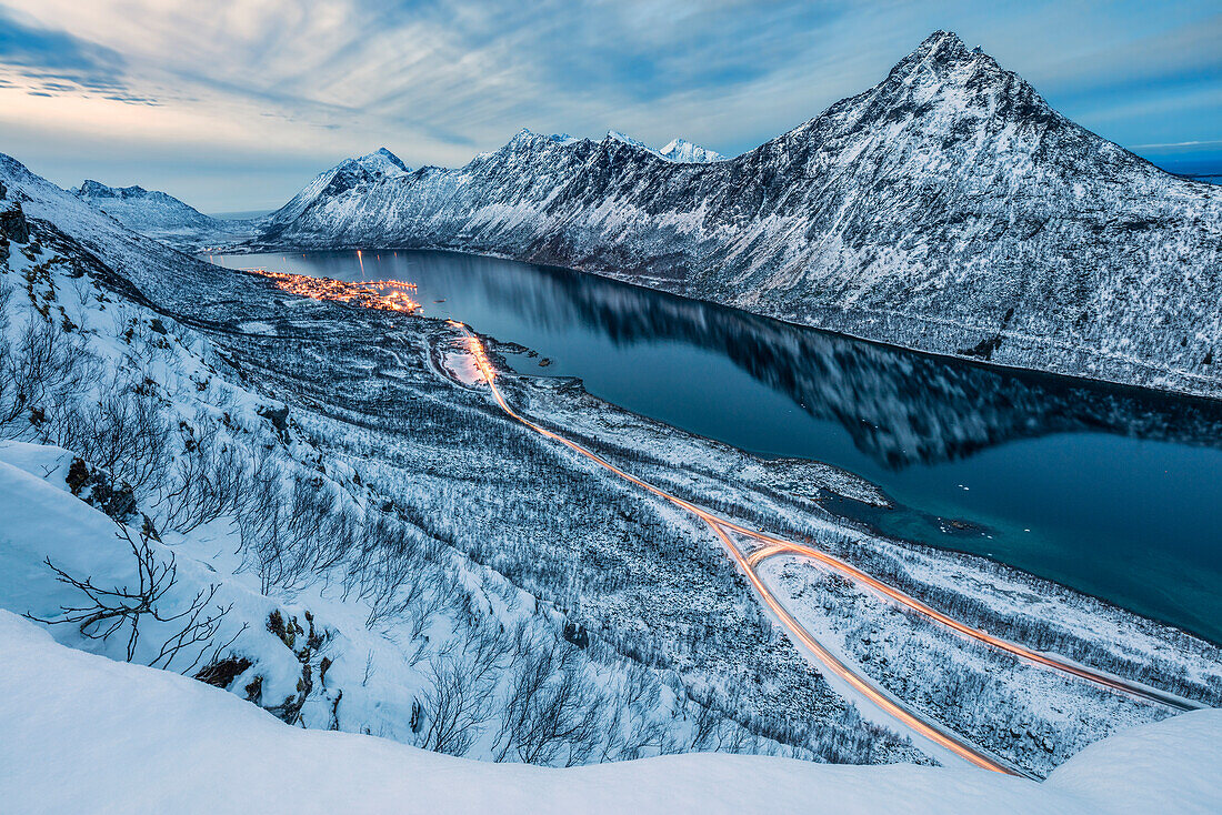 Die schneebedeckten Gipfel über dem gefrorenen Meer umrahmt von den blauen Lichter der Dämmerung, Gryllefjorden, Senja, Troms County, Arktis, Norwegen, Skandinavien, Europa