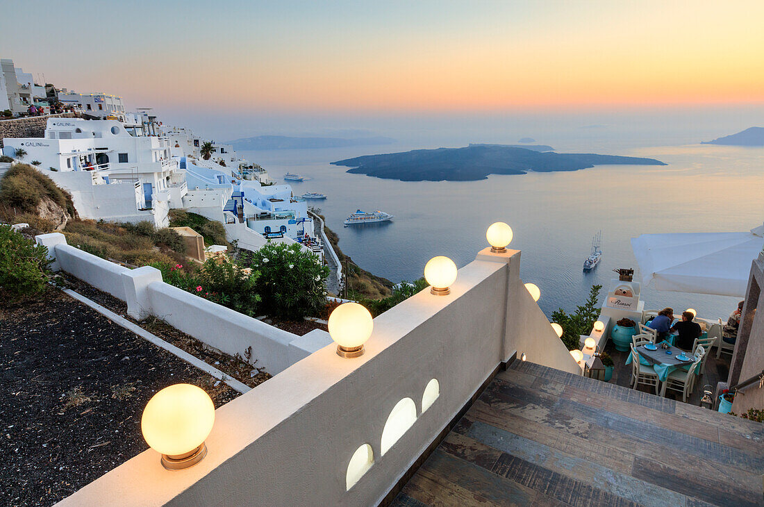 The fiery red sky on the Aegean Sea after sunset seen from the typical terraces of Firostefani, Santorini, Cyclades, Greek Islands, Greece, Europe