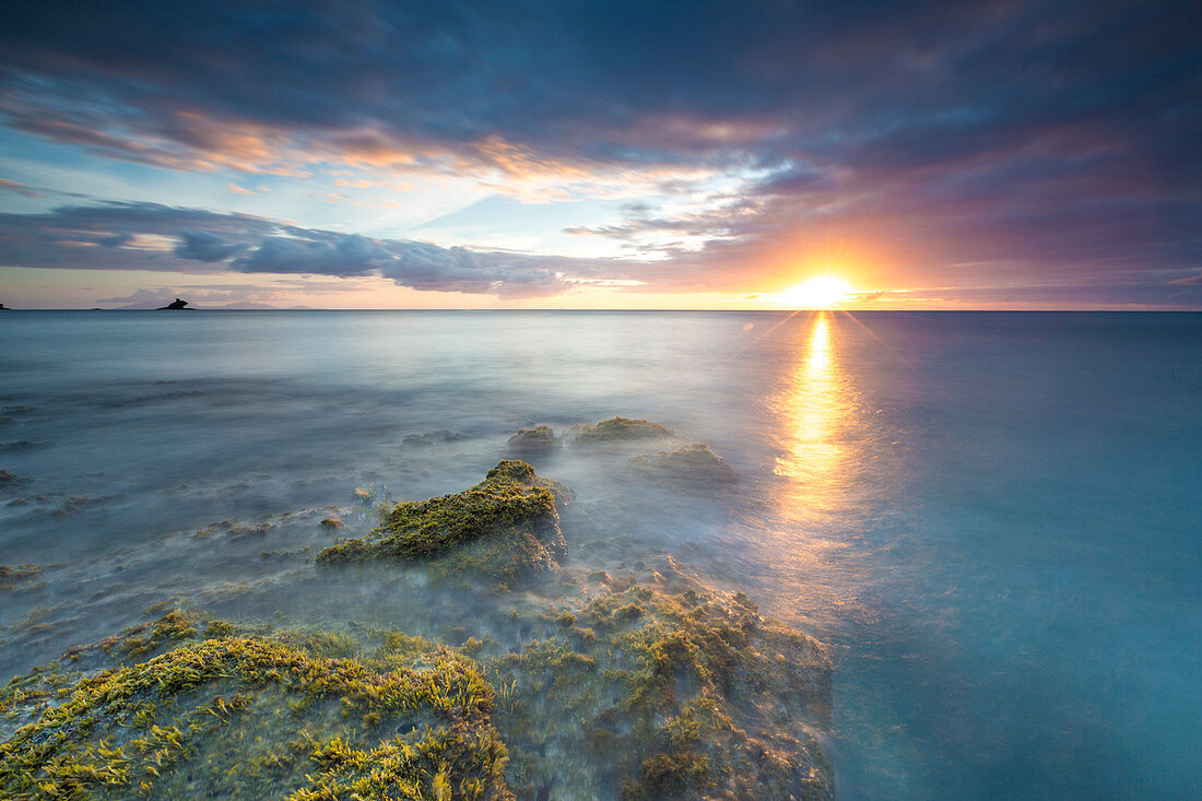 Die Lichter des Sonnenuntergangs spiegeln sich im blauen Meer Hawksbill Bay, Antigua, Antigua und Barbuda, Leeward Inseln, Westindische Inseln, Karibik, Mittelamerika