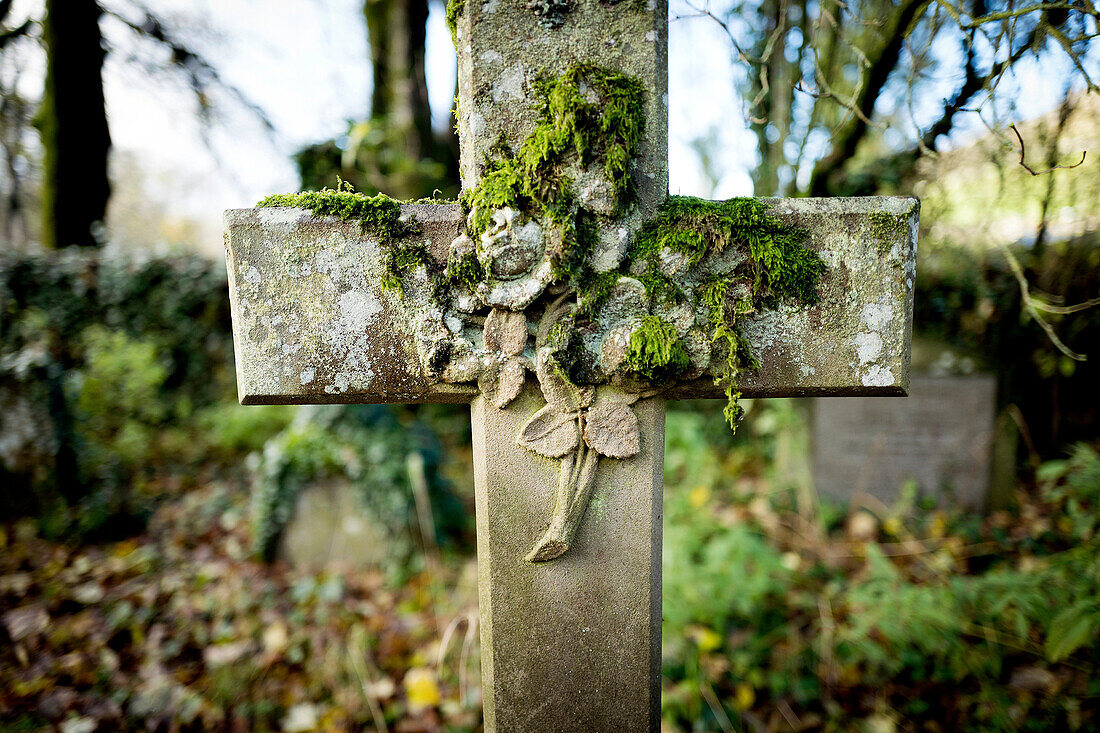 Close-up of a cross with flowers embossed on the stone. Arncliffe Church, Arncliffe, Skipton, Yorkshire Dales, North Yorkshire, England, UK, Europe.