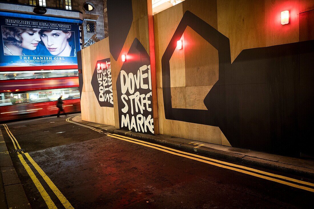 Straßenecke mit Bus in verschwommener Bewegung, Fußgänger und Filmplakat von 'The Danish Girl'. Haymarket, London, England