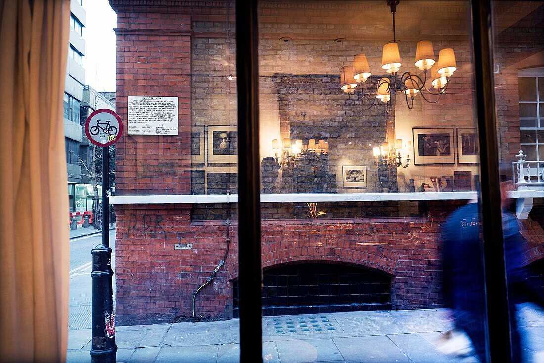 Blick auf die Straße durch Fenster. Lampe, Möbel und Fotografien spiegelt sich im Glas. Silber Pl. , Soho, London, England