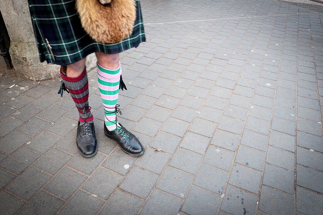 Unrecognizable man wearing typical Scottish costume and 'odd socks'. London, England