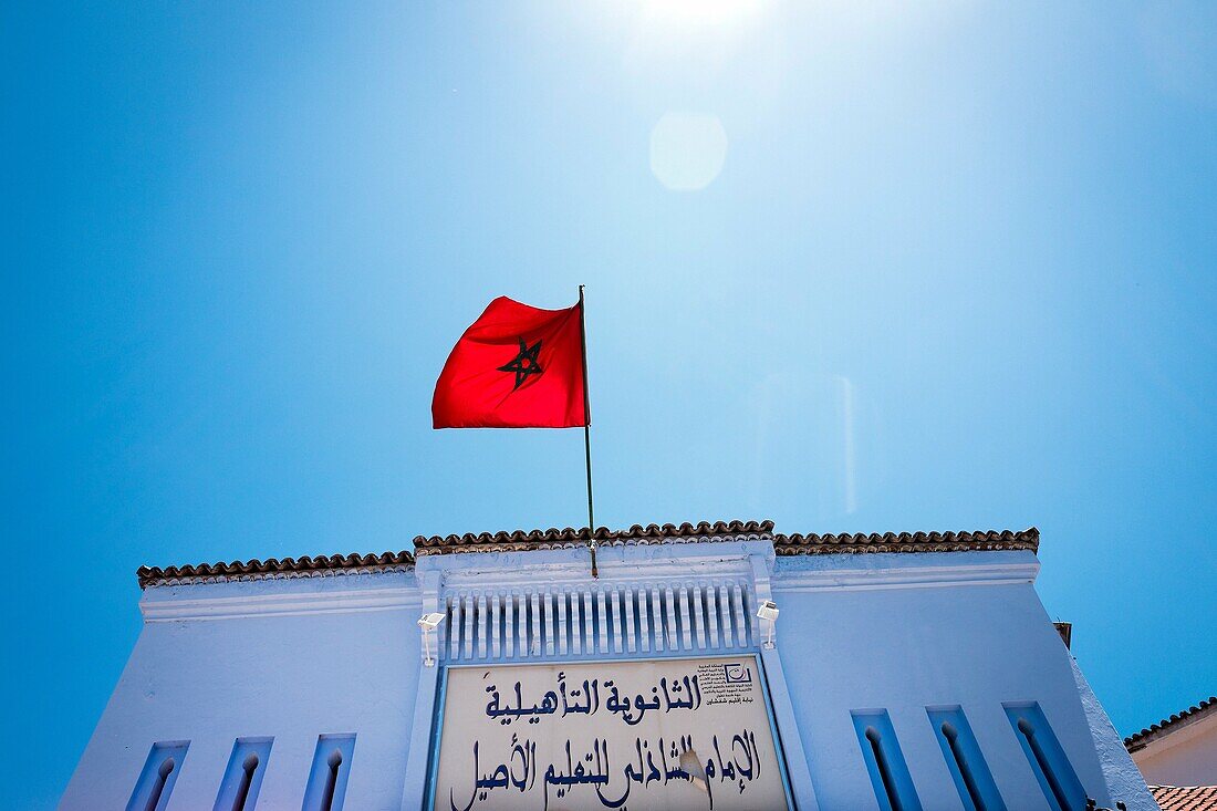 Marokkanische Flagge winkend über Gebäude. Chaouen, Marokko